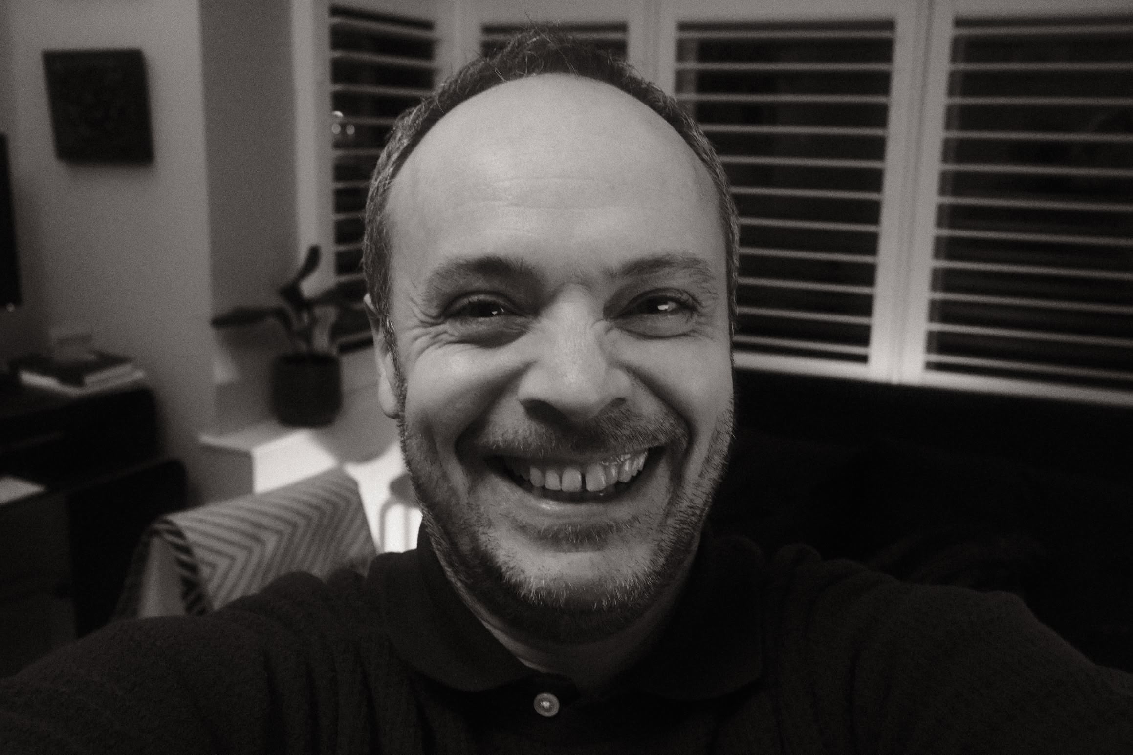 A black and white selfie of someone smiling.