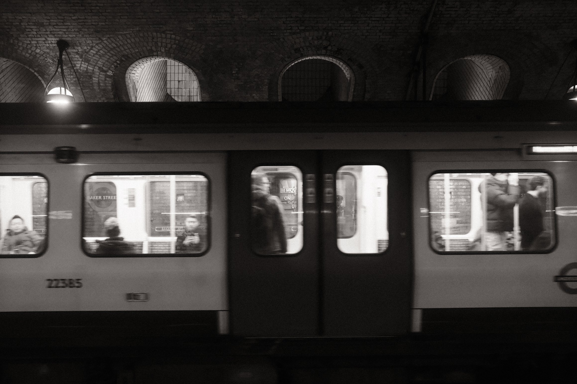A black and white photo of a Hammersmith & City Line train at Baker Street in London
