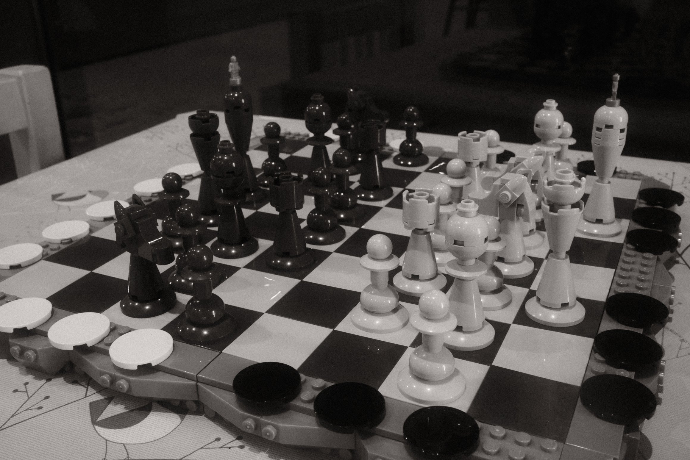 a black and white photo of a Lego chess board