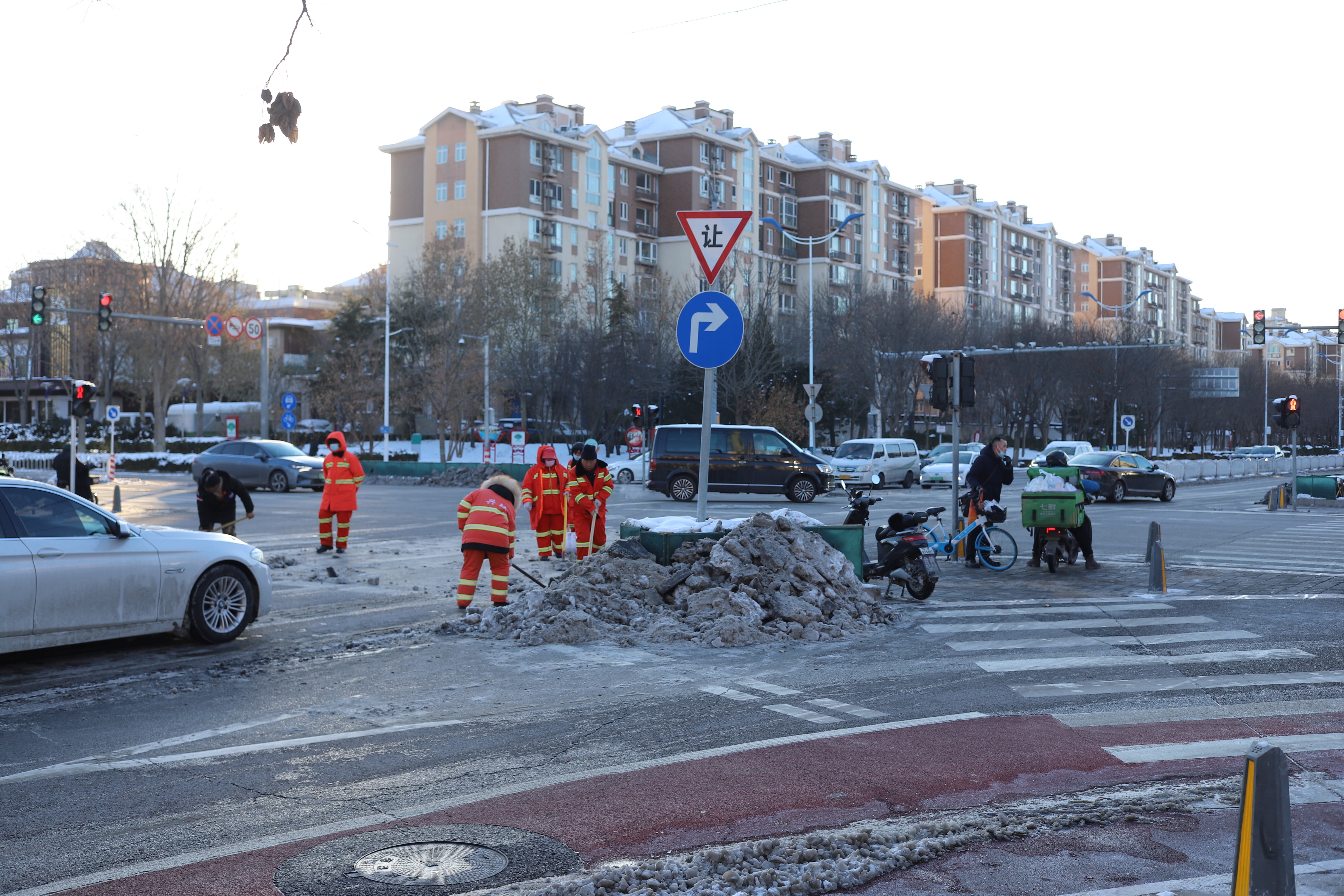 The work to clear ice and snow from the roads is never ending. As cars wait at the red lights, workers rush out to try and clear more of the ice off the roads in front of them.